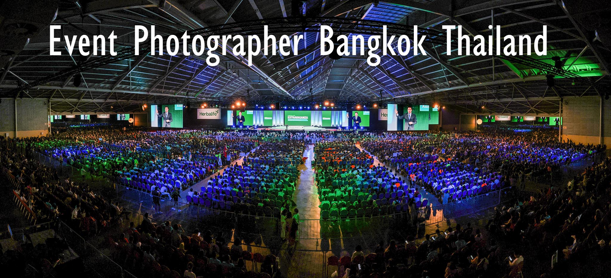 Bangkok event photographer in Thailand convention hall company event stage green and blue lights and stage with attendees